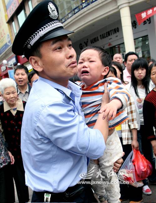 男民警抱起小孩时,孩子"哇"的一声大哭起来,连声说:"警察叔叔,你抓错