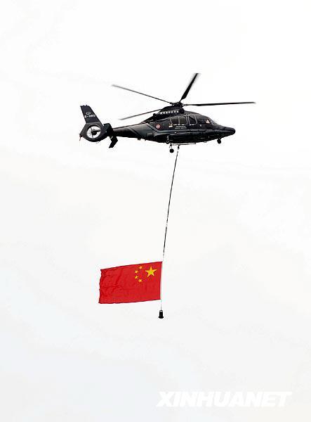 9月27日,一架悬挂国旗的直升机从维多利亚湾上空飞过.
