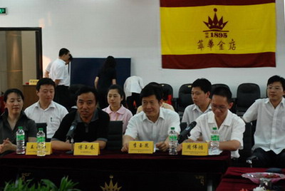 萃华金店董事长李玉昆(前排右二)与总经理周伟鸿(前排右一)与记者们