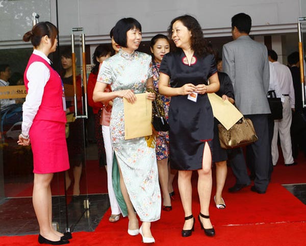 两位身穿旗袍的女委员在会议结束后从大会堂内走出。 