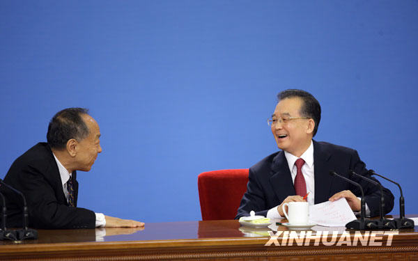 3月13日，国务院总理温家宝在北京人民大会堂与中外记者见面，并回答记者提问。这是温家宝与大会发言人李肇星交流。