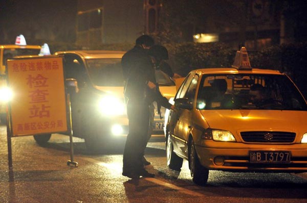 警方漏夜彻查，在安全检查站检查车辆。