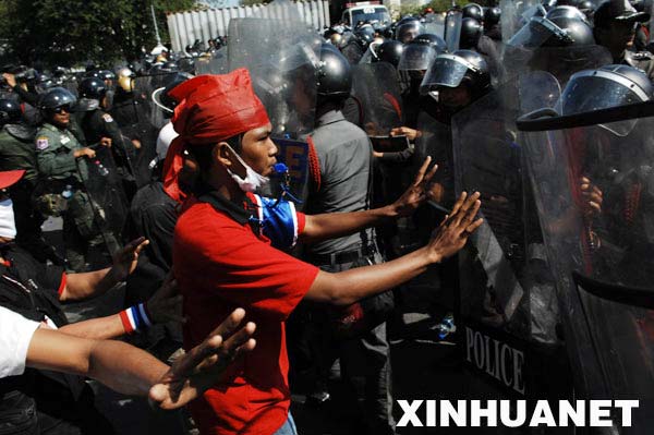 3月26日，一名泰国反独裁民主联盟（反独联）的支持者在曼谷总理府外与警察对峙。当日，反独联的支持者在曼谷举行大规模反政府集会并包围了总理府。新华社发（塔纳摄）