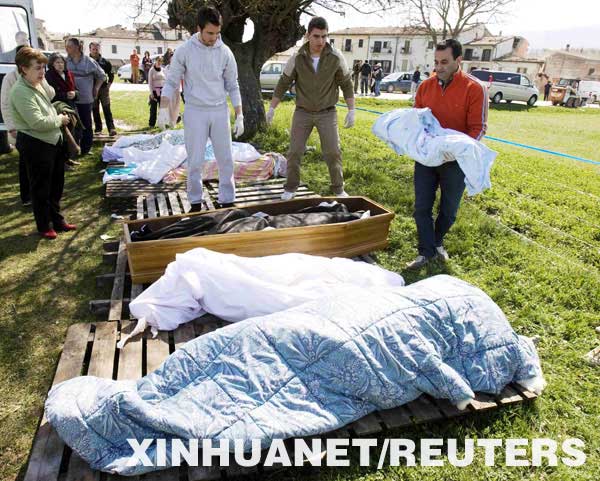 4月6日,，在意大利中部地區(qū)一個村莊，一名驗尸官（右）將一對在地震中遇難的母嬰的遺體放在一起,。