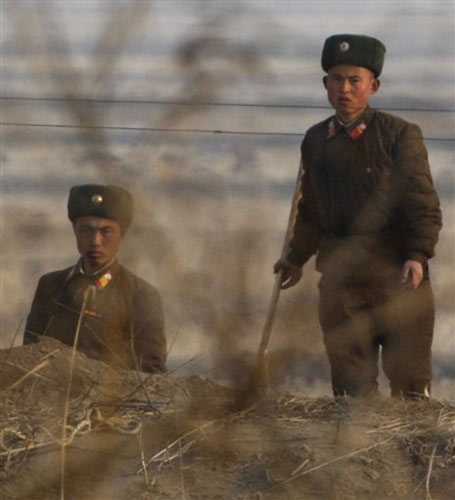 面对西方记者的镜头“骚扰”，朝鲜军人警惕的停下了手中的工作。