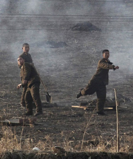 面对西方记者的镜头“骚扰”，朝鲜军人用石头回击。