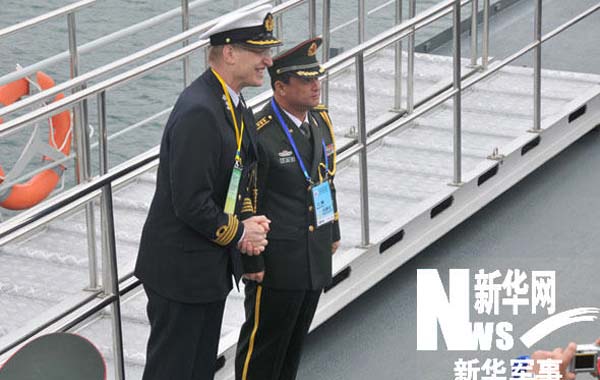 一名外国海军军官在观摩舰甲板上与中国军人合影留念。