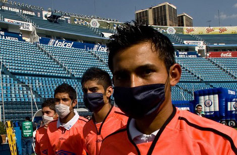 墨西哥足球赛事禁止球迷入场观看，场边球童戴口罩工作。