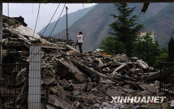  5月10日，在北川老县城，一位母亲站在废墟上痛哭，悼念因地震丧生的孩子。