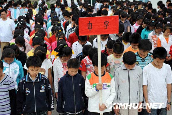 5月12日，中学生在纪念活动上为遇难者默哀。当日，四川青川县木鱼镇举行“5·12”汶川大地震一周年纪念活动。各界代表参加活动，悼念遇难同胞。
