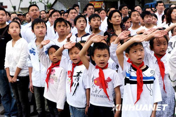  5月12日，小学生在升旗仪式上高唱国歌。