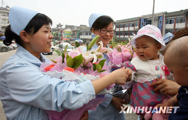 5月11日，“地震宝宝”代无极（左三）和护士罗云莉阿姨（左一）握手。