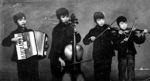 1959年，当时参加重庆市少年宫乐队的两对小兄弟（左起依次为）肖能定、肖能铸,张小弓、张小弦，认真为“六一”活动排练。肖氏兄弟、小弓都已退休,小弦现任新加坡某大学教授。

