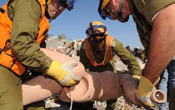 6月2日，在以色列南部的加特镇，参加仿导弹袭击演习的以色列士兵在一处房屋废墟里转移“伤员”。这次演习是以色列为期5天的全国范围应急演习的一部分。此次应急演习代号为“转折点3”，是迄今为止以色列举行的最大规模演习。 新华社记者殷博古摄