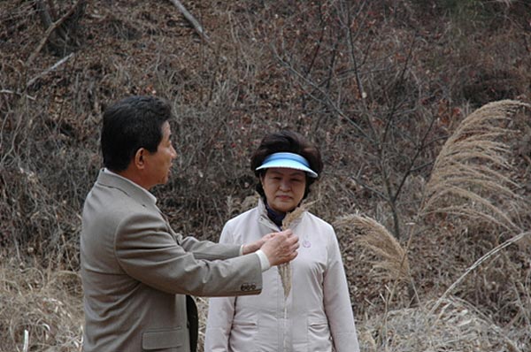 2008年3月13日 总统府旁紫岩沟散步途中，前总统卢武铉向权良淑女士解释说明紫芒的种类。