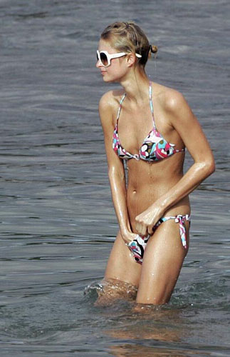 2005年12月，夏威夷，来此度假的Paris Hilton穿着彩色花纹比基尼，那时的她似乎比现在还要瘦削，突出的锁骨演绎了女性神秘莫测的美。宽线条镜框的太阳镜和她的脸型很配。
