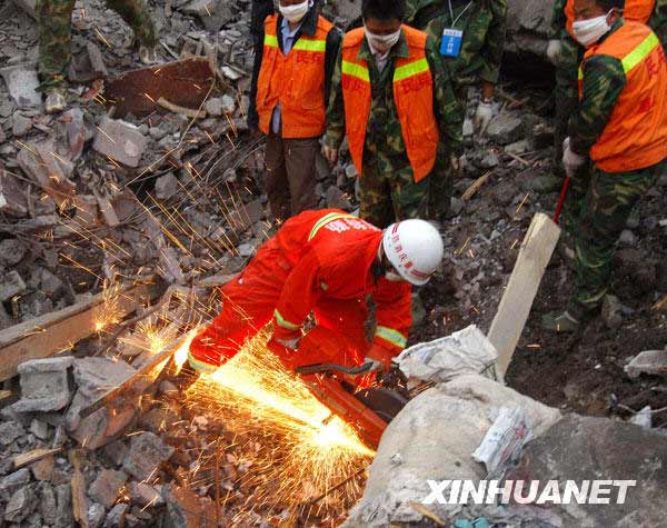 6月7日，重慶消防總隊的消防戰(zhàn)士用切割機切割掩埋遇難者遺體廢墟上的鋼筋,。新華社記者劉潺攝