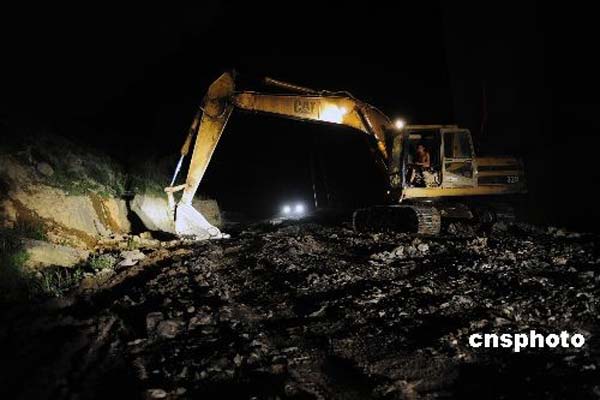 6月7日凌晨，大型机械正在对重庆武救援通道坑洼地段进行填补。