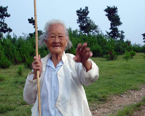 這個老太太就是剛才講的,，一個人柱著竹桿，靜靜地走上高地來,，她幾時站在我身旁,，都沒有注意,，當(dāng)我轉(zhuǎn)過身時，她伸出三個手指,，不斷地說：三個鬼,、三支槍。 當(dāng)時,，左側(cè)坡后的樹后,，藏著一個桂軍副官，用手槍三槍打死三個日本鬼子,，繳獲了三支三八槍,，背起就跑，跑到一個水塘就丟了進去,。戰(zhàn)后桂軍論功行賞,，副官報告說自己干掉三個日本鬼子，長官不信,，帶著一隊人來到水塘,，副官跳進水塘，撈起了三支三八槍,。 當(dāng)?shù)乩夏甏迕裼腥酥v,，過去村子的大人都講，“廣西猴子”（桂軍）的槍法都很準(zhǔn),。 因為時間,，我向老太太揮揮手就趕下跟著老人走了，沒有來得及與老人多講幾句話,。 下次再去時,，希望能看到這老太太，陪她多講幾句話,。老太太祝你健康長壽,。 