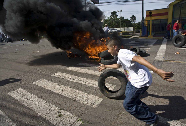 6月28日，在洪都拉斯首都特古西加尔巴，民众在总统府门前燃烧轮胎，要求释放总统塞拉亚。