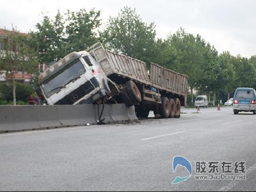 疲劳驾驶酿车祸 货车爬上隔离墩