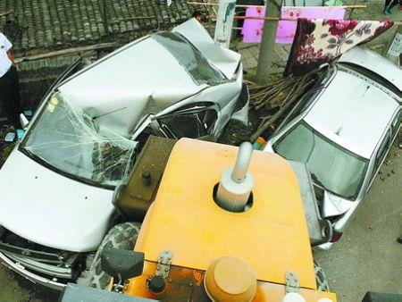 前车掉下一辆压路机压扁路边两辆小轿车